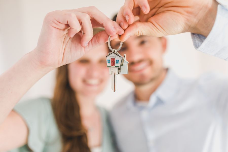 A couple holding up the keys to a home
