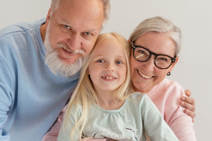 Grandparents hugging their grandchild